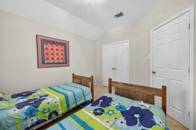 a bedroom with two bed and a painting on the wall