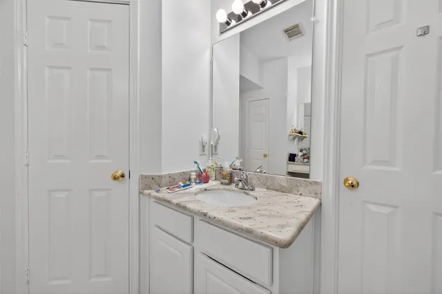 a bathroom with a granite countertop sink and a mirror