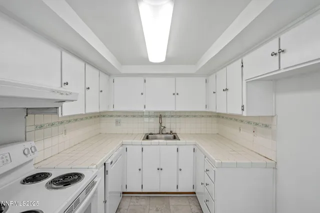 a kitchen with a sink a stove and cabinets