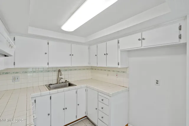 a kitchen with stainless steel appliances granite countertop white cabinets and a sink