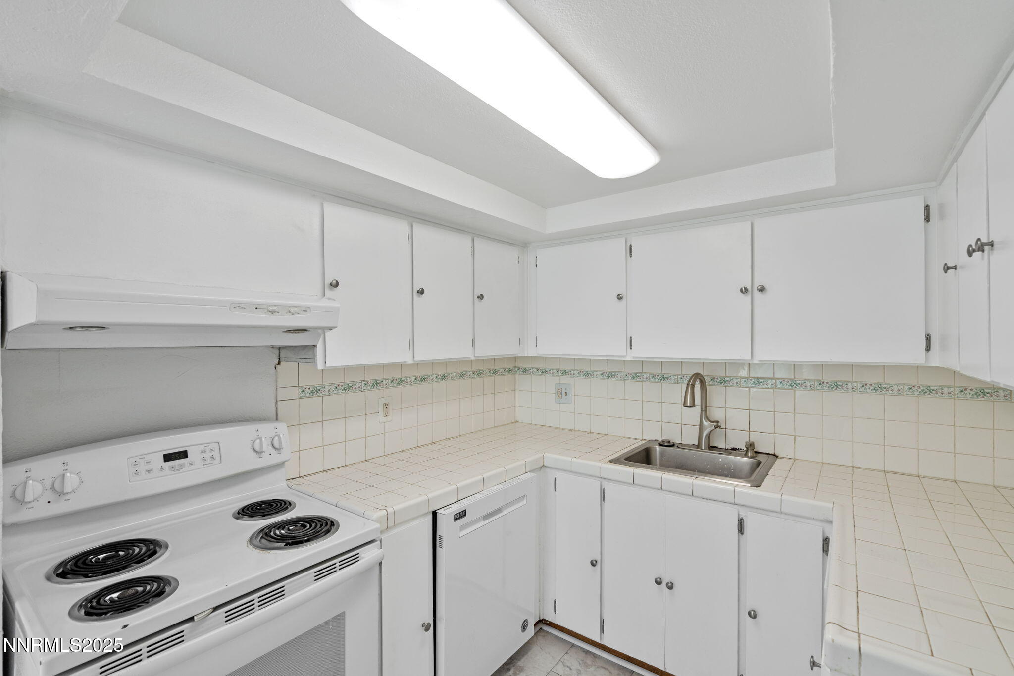 1889 Merchant Street Sparks, NV 89431 - Photo 17 of 28 a kitchen with white cabinets and appliances