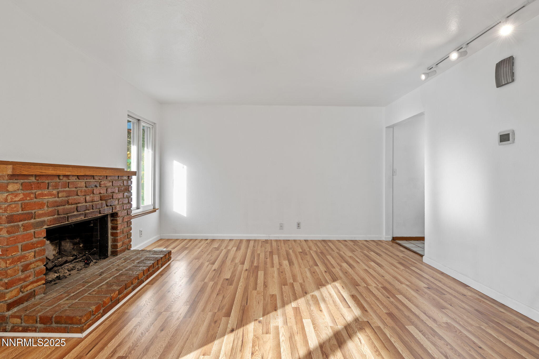1889 Merchant Street Sparks, NV 89431 - Photo 6 of 28 a view of empty room with wooden floor and fireplace