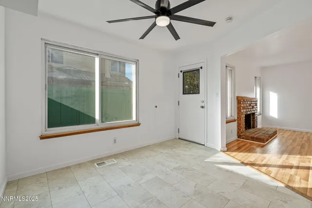 a view of a livingroom with a chandelier fan and windows