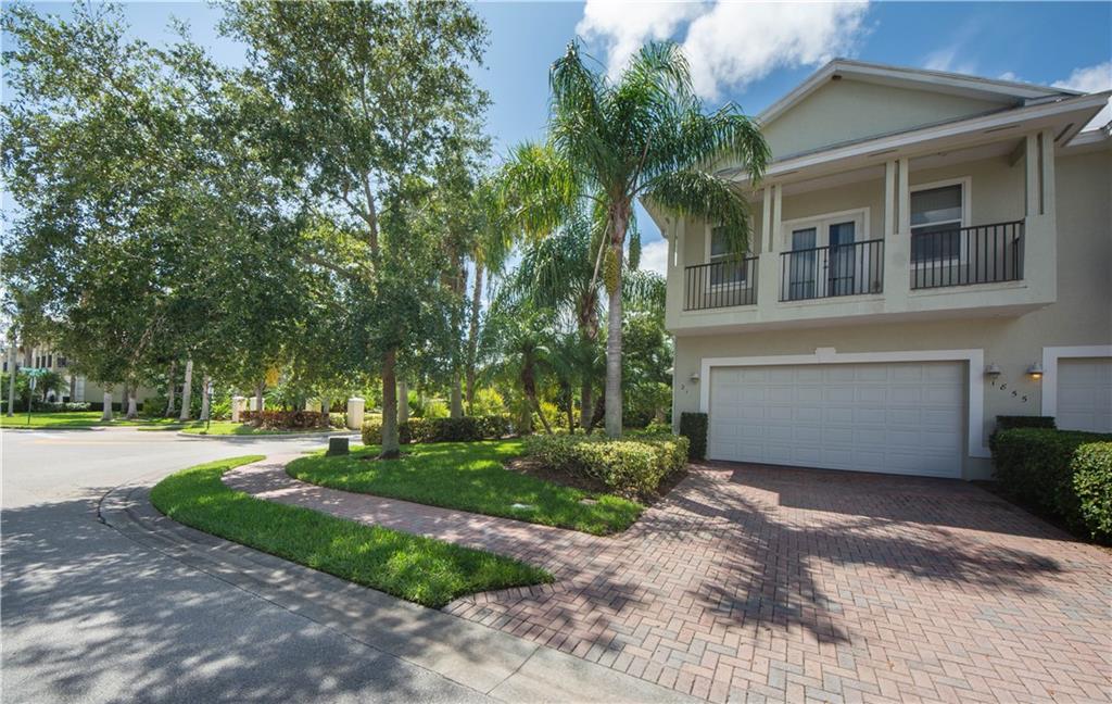 1855 Bridgepointe Circle, Unit 21 Vero Beach, FL 32967 - Photo 2 of 35 a front view of a house with a garden and trees