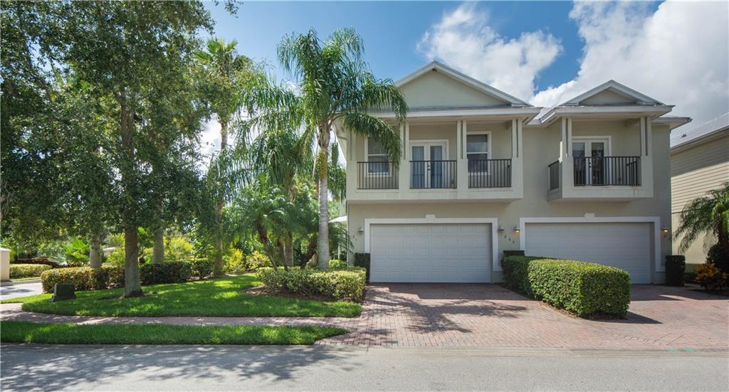 1855 Bridgepointe Circle, Unit 21 Vero Beach, FL 32967 - Photo 3 of 35 a front view of a house with a garden and trees