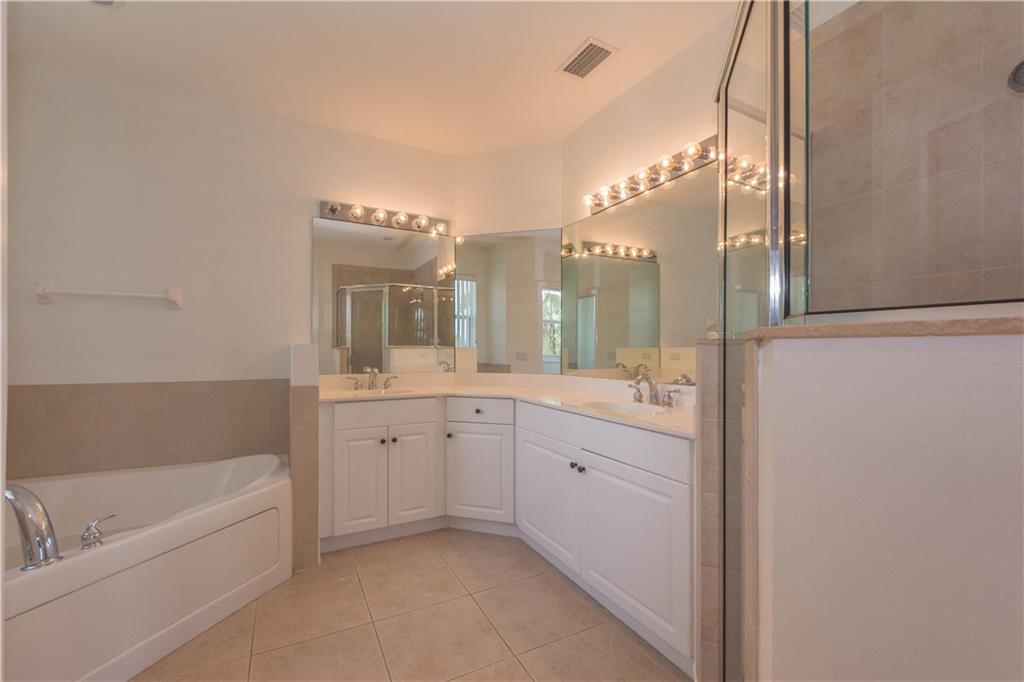 1855 Bridgepointe Circle, Unit 21 Vero Beach, FL 32967 - Photo 24 of 35 a spacious bathroom with a tub sink and mirror