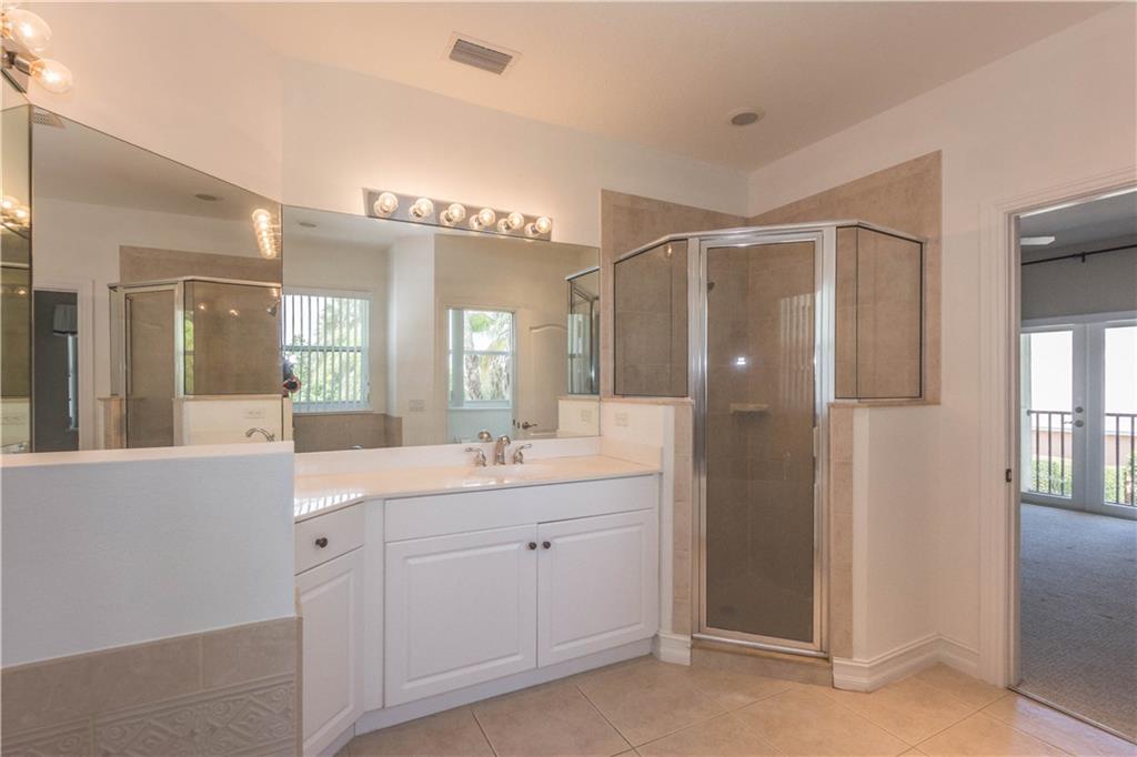 1855 Bridgepointe Circle, Unit 21 Vero Beach, FL 32967 - Photo 25 of 35 a bathroom with a double vanity sink mirror and shower