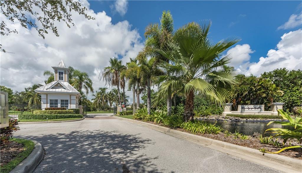 1855 Bridgepointe Circle, Unit 21 Vero Beach, FL 32967 - Photo 31 of 35 a view of a house with a yard and palm trees