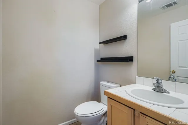 a bathroom with a toilet a sink and mirror