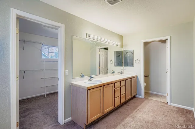 a spacious bathroom with a double vanity sink and a mirror