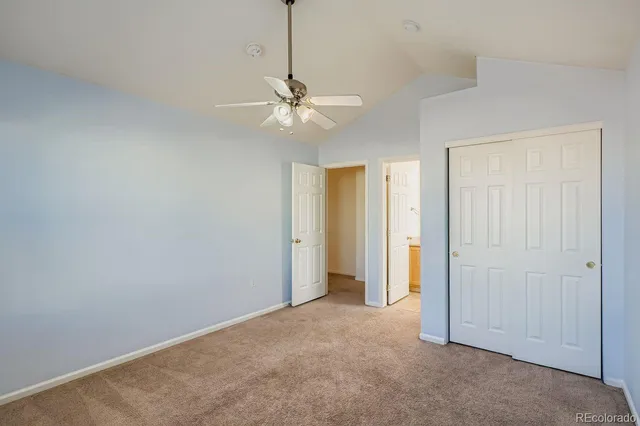 an empty room with a ceiling fan and a window