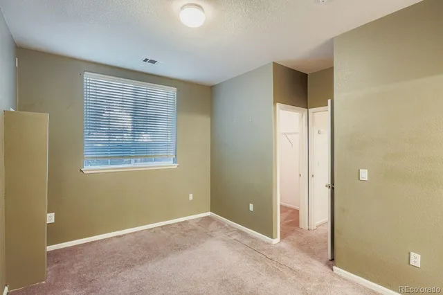 an empty room with windows and closet