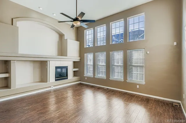 a view of an empty room with a fireplace and a window