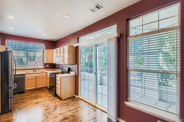 a kitchen with stainless steel appliances granite countertop sink stove and refrigerator
