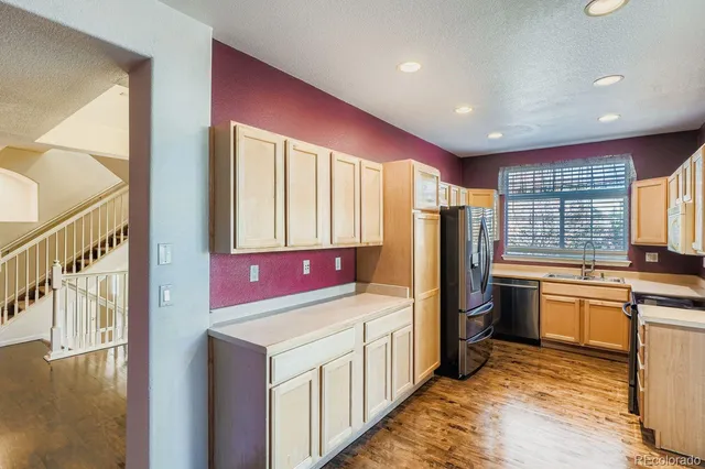 a kitchen with refrigerator cabinets and wooden floor