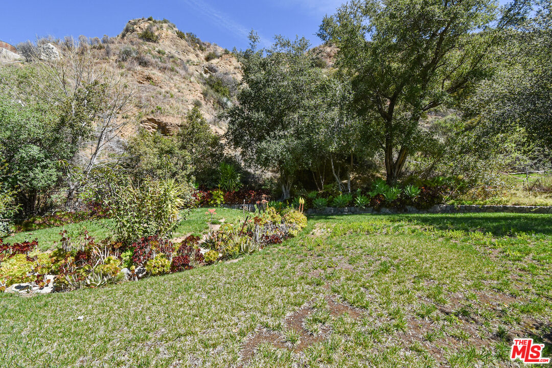 2447 Stonyvale Road Tujunga, CA 91042 - Photo 21 of 33 a view of a garden with a bench