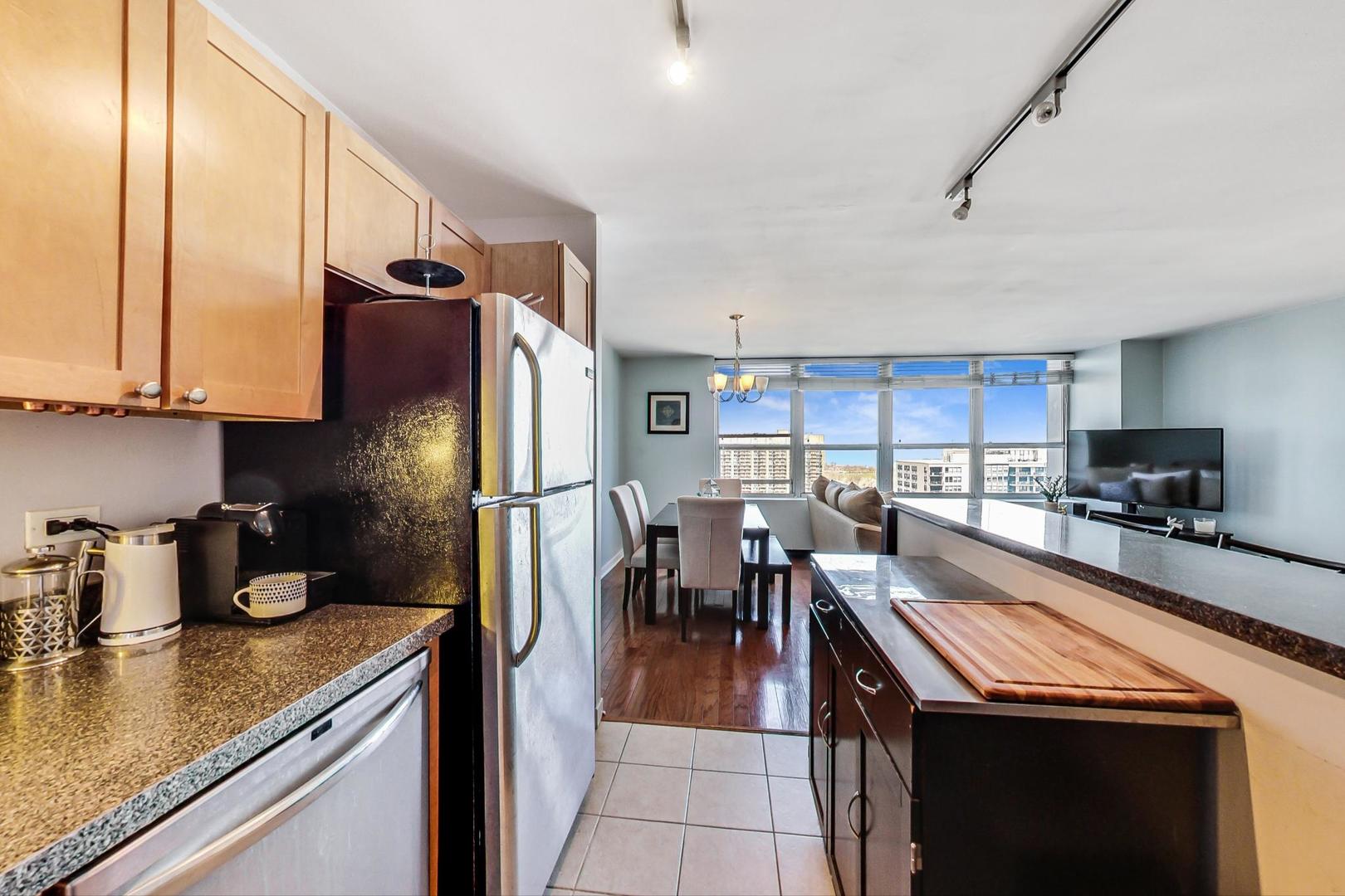 655 West Irving Park Road, Unit 2108 Chicago, IL 60613 - Photo 16 of 34 a kitchen with stainless steel appliances granite countertop a sink a stove and a refrigerator
