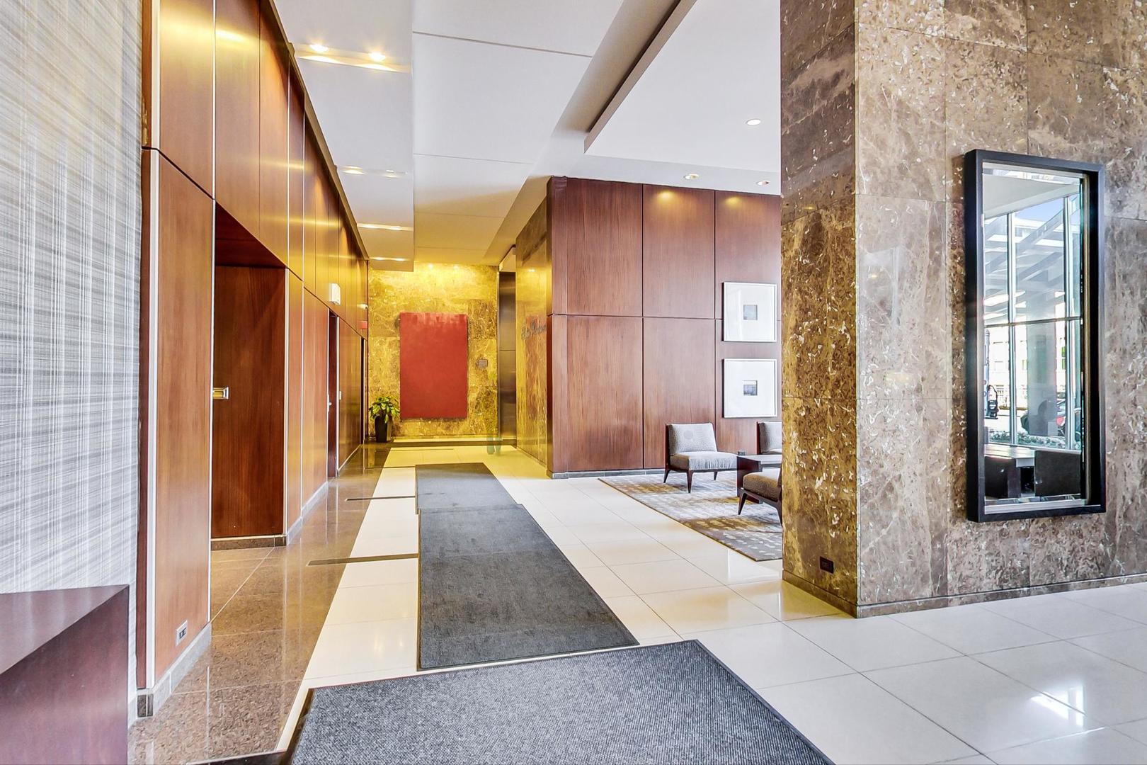 655 West Irving Park Road, Unit 2108 Chicago, IL 60613 - Photo 5 of 34 a view of a hallway with large mirror and furniture