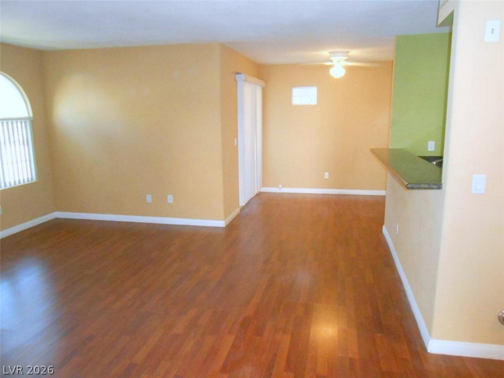 9325 West Desert Inn Road, Unit 132 Las Vegas, NV 89117 - Photo 3 of 36 Natural light illuminates rich hardwood flooring in this spacious living area, flowing into a convenient kitchen counter.