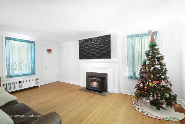 a living room with a fireplace and flower plants
