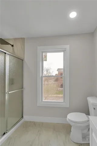 a bathroom with a toilet a sink and a window