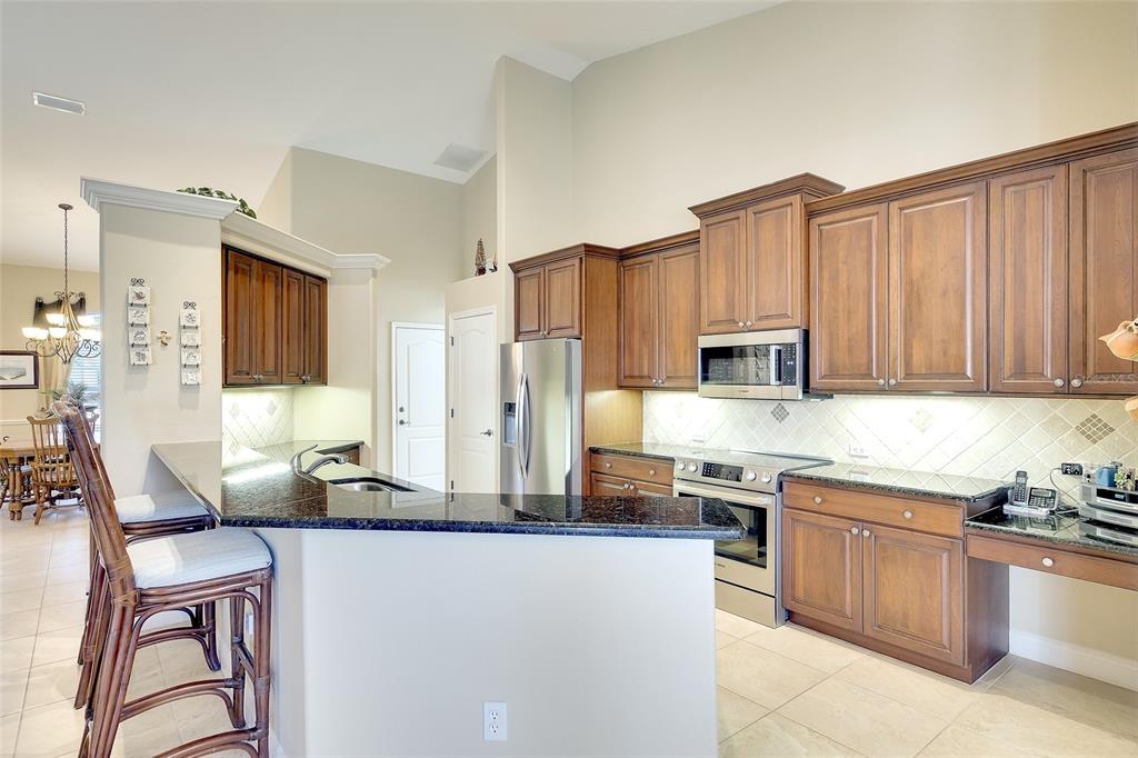 11809 Oak Ridge Drive Parrish, FL 34219 - Photo 11 of 39 a kitchen with stainless steel appliances granite countertop a stove top oven a sink dishwasher and a refrigerator