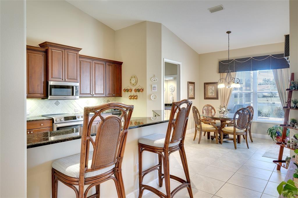 11809 Oak Ridge Drive Parrish, FL 34219 - Photo 12 of 39 a dining room with furniture a window and kitchen view