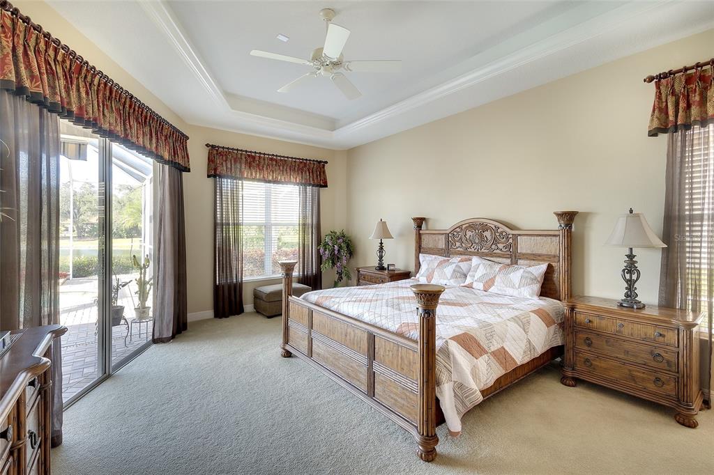 11809 Oak Ridge Drive Parrish, FL 34219 - Photo 17 of 39 a bedroom with a bed lamp and a large window