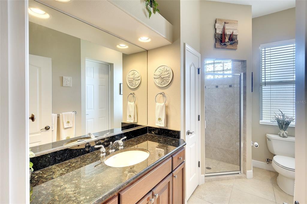 11809 Oak Ridge Drive Parrish, FL 34219 - Photo 26 of 39 a spacious bathroom with a granite countertop sink and a mirror