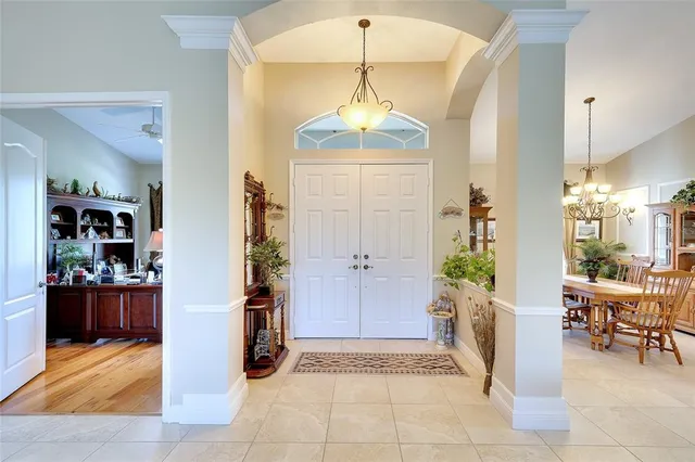 a view of a hallway with dining room and chandelier