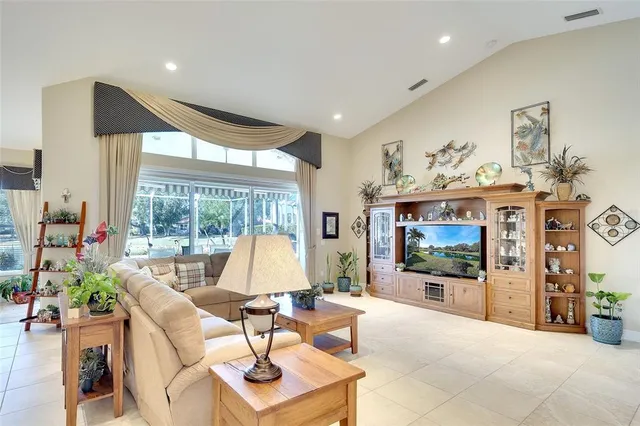 a living room with furniture a flat screen tv and a floor to ceiling window