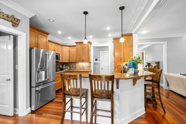 a view of kitchen with stainless steel appliances granite countertop a refrigerator and cabinets