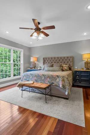 a bedroom with a bed and a flat tv screen on dresser