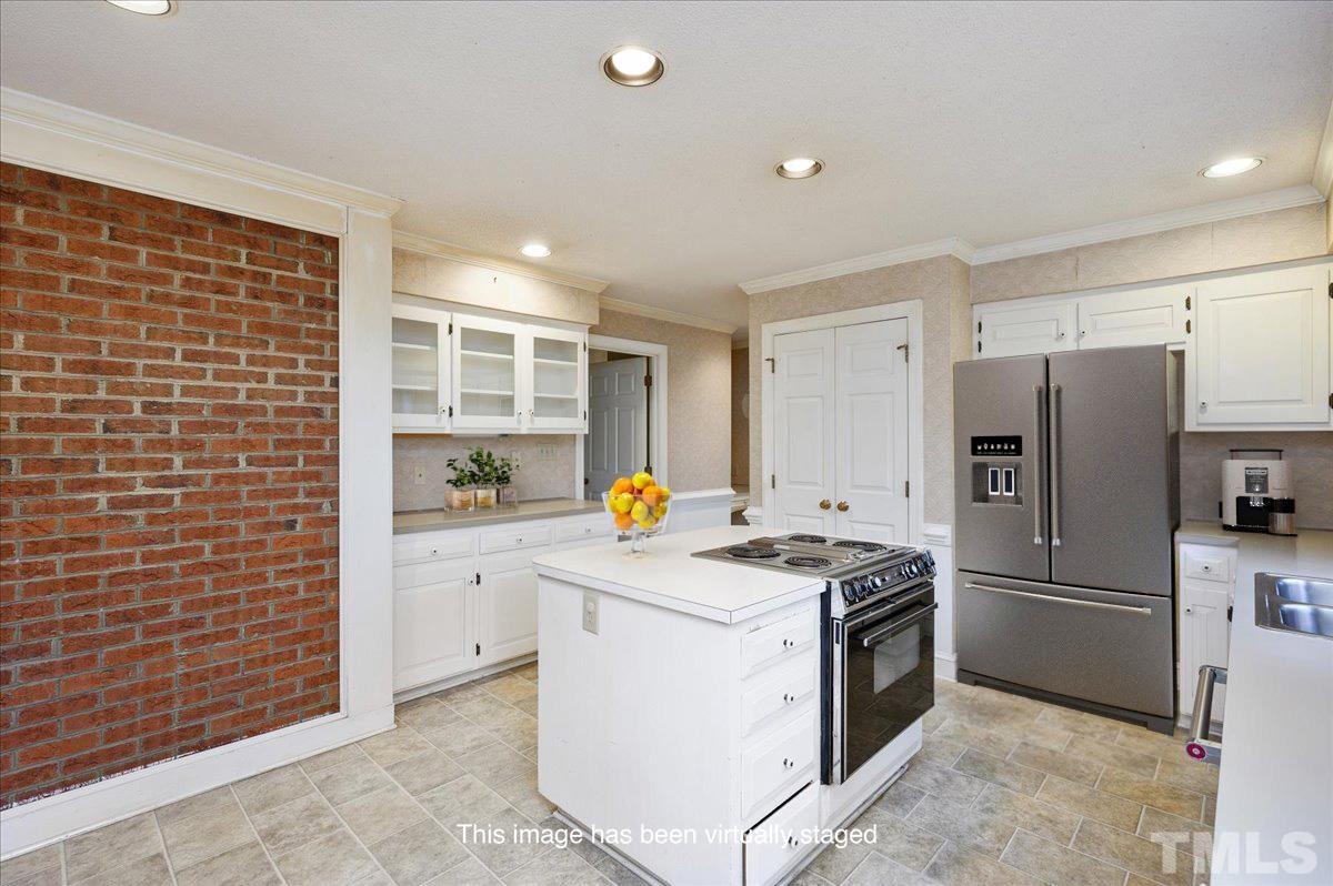 4112 Landfall Court Raleigh, NC 27613 - Photo 14 of 27 a kitchen with a stove a refrigerator and white cabinets