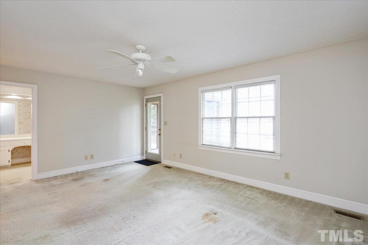 4112 Landfall Court Raleigh, NC 27613 - Photo 22 of 27 an empty room with chandelier fan and windows