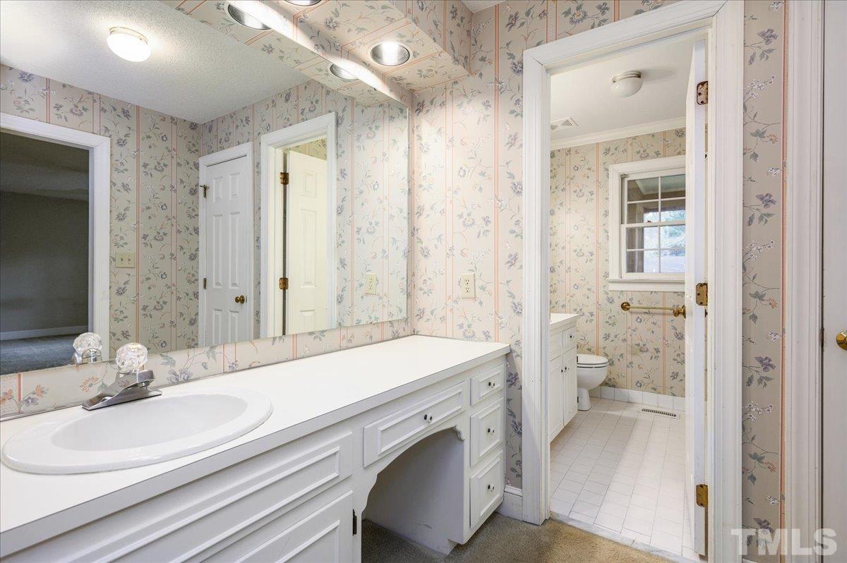 4112 Landfall Court Raleigh, NC 27613 - Photo 23 of 27 a bathroom with a sink a toilet and shower
