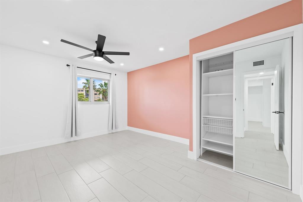 877 Northeast 195th Street, Unit 422 Miami, FL 33179 - Photo 14 of 23 a view of empty room with wooden floor and ceiling fan