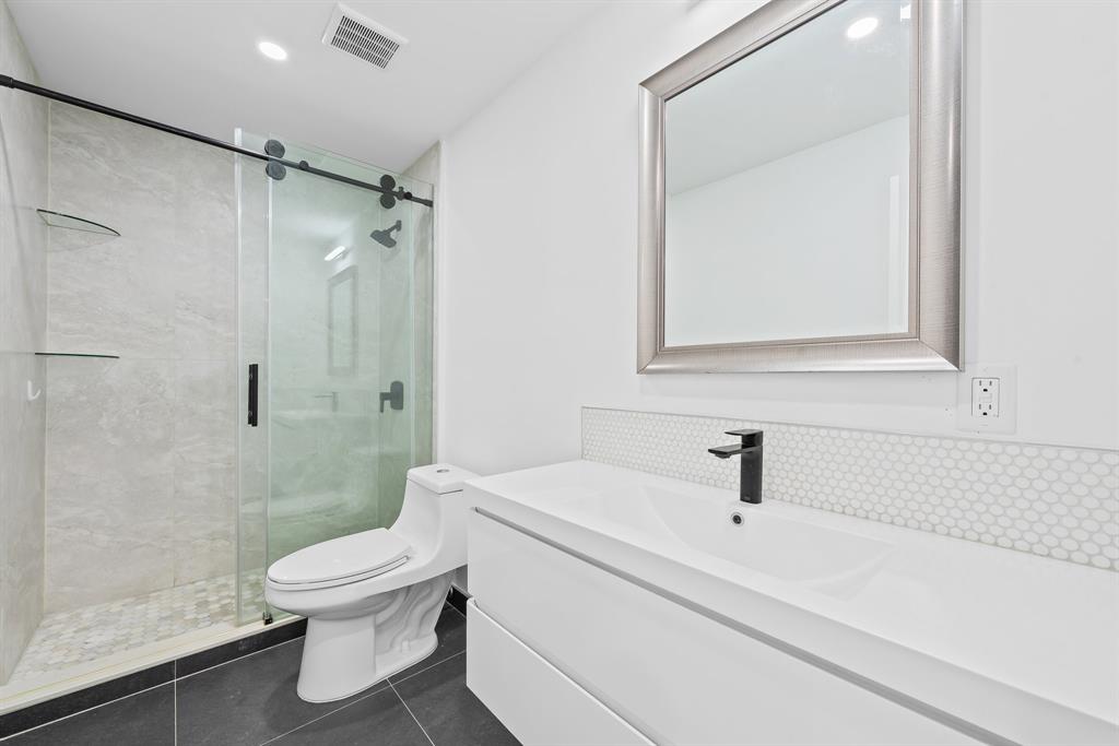 877 Northeast 195th Street, Unit 422 Miami, FL 33179 - Photo 15 of 23 a white toilet sitting next to a bath tub