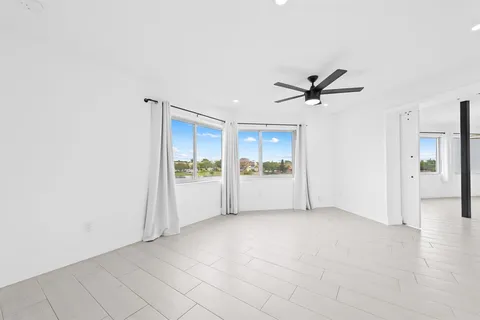 a view of a livingroom with a ceiling fan and window