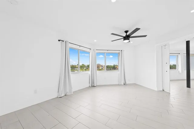 a view of a livingroom with a ceiling fan and window