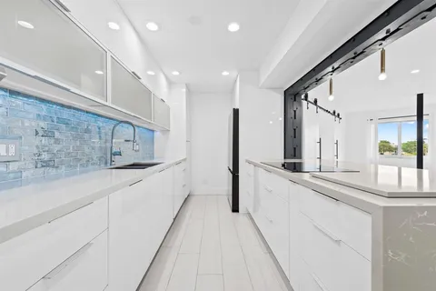 a large white kitchen with a large window
