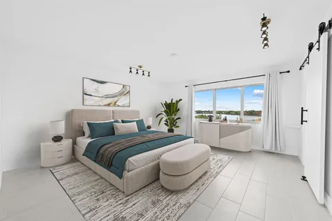 a bedroom with a large bed and a view of kitchen