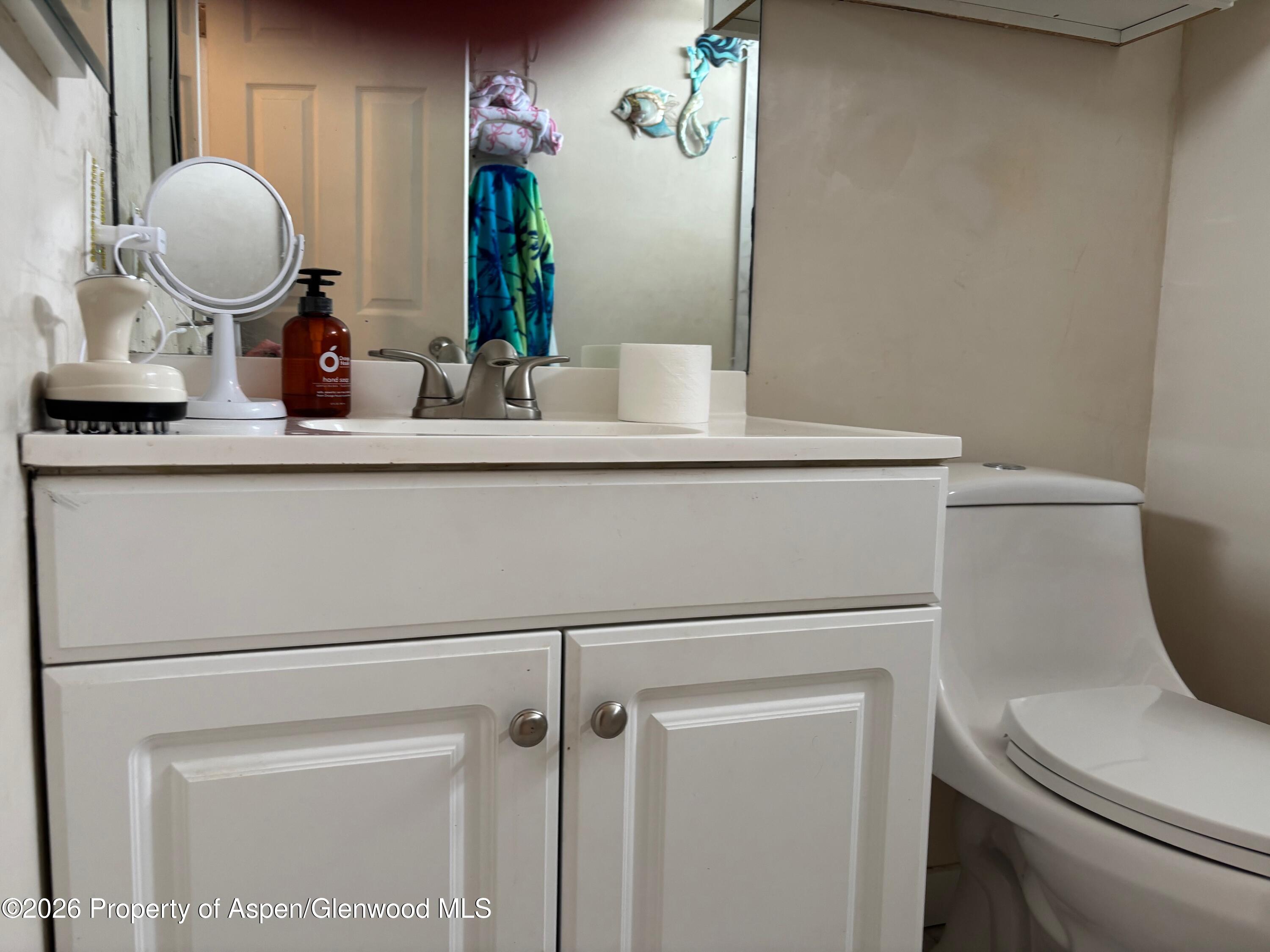 2603 Acacia Avenue Rifle, CO 81650 - Photo 12 of 29 a bathroom with a toilet a sink and a mirror