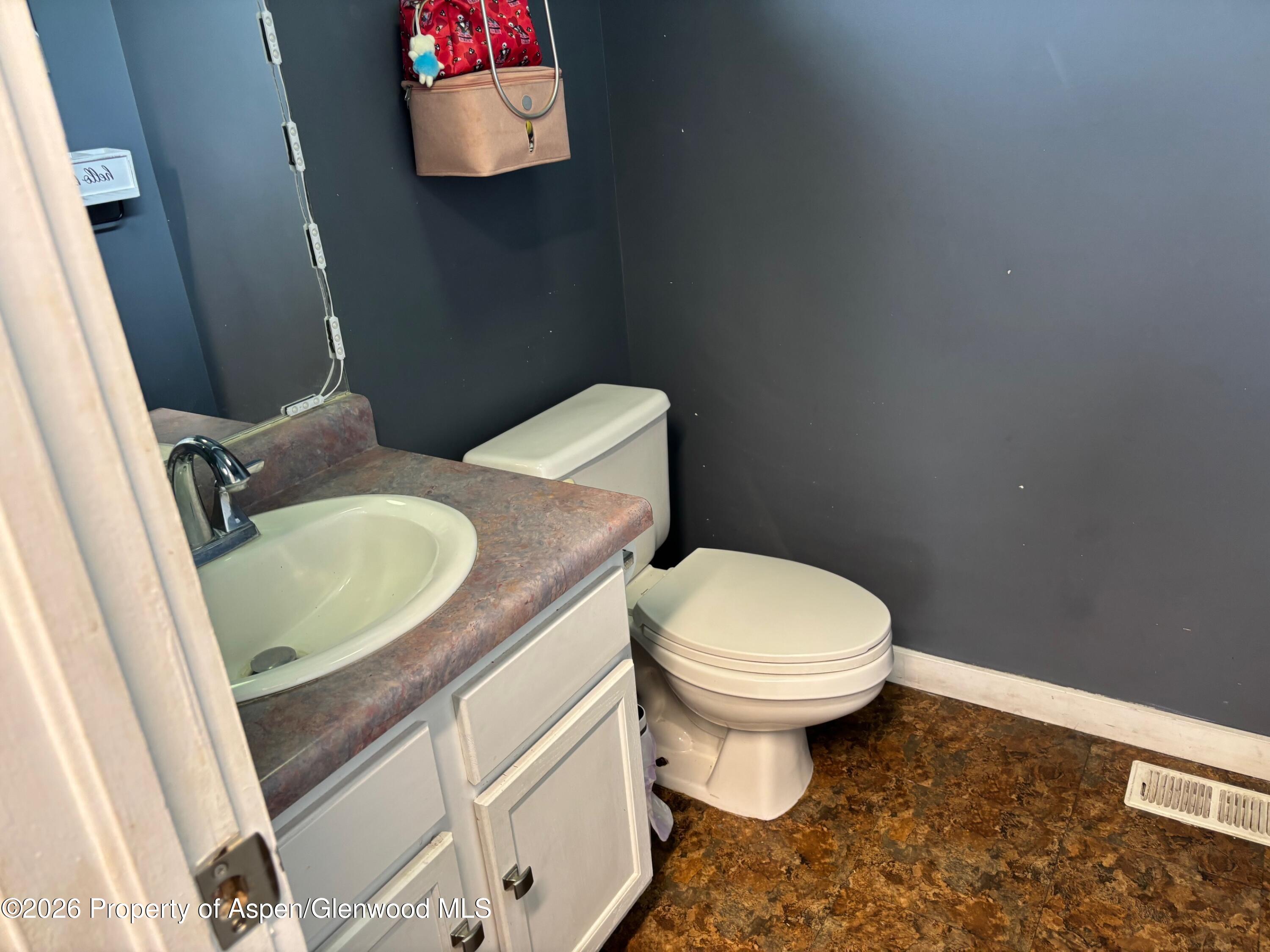 2603 Acacia Avenue Rifle, CO 81650 - Photo 19 of 29 a bathroom with a toilet sink vanity and mirror