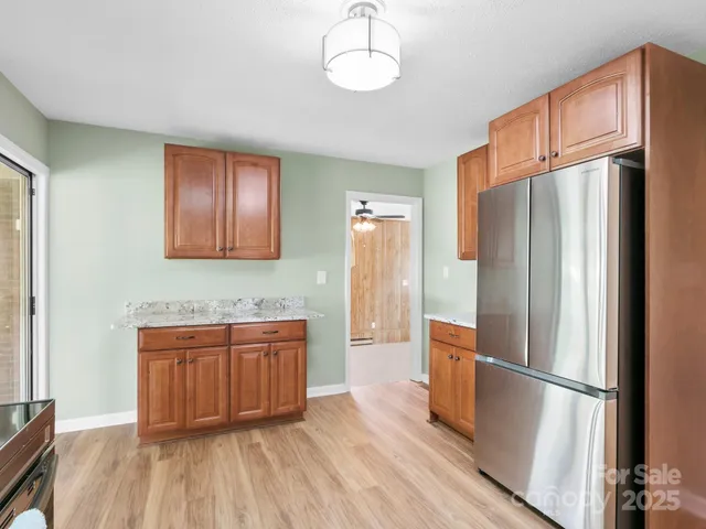a kitchen with stainless steel appliances granite countertop a refrigerator and a sink