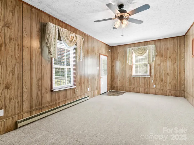 a view of an empty room with a window and a chandelier fan