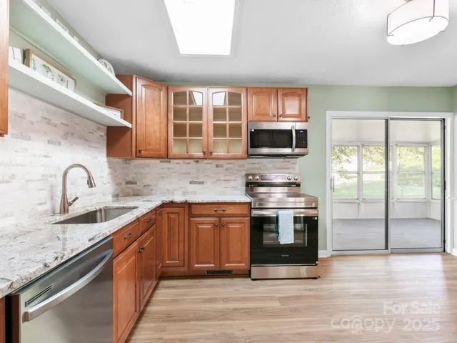 a kitchen with stainless steel appliances granite countertop a stove sink and microwave