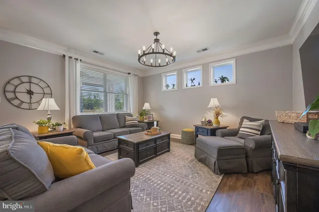 a living room with furniture a window and wooden floor