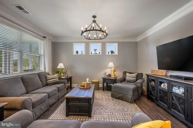 a living room with furniture a flat screen tv and a window