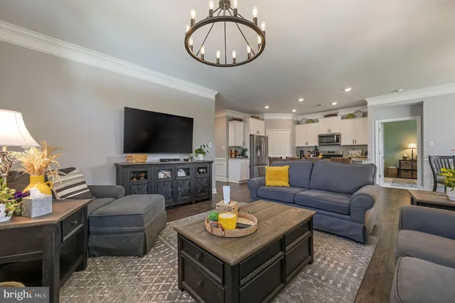 a living room with furniture and a flat screen tv with kitchen view